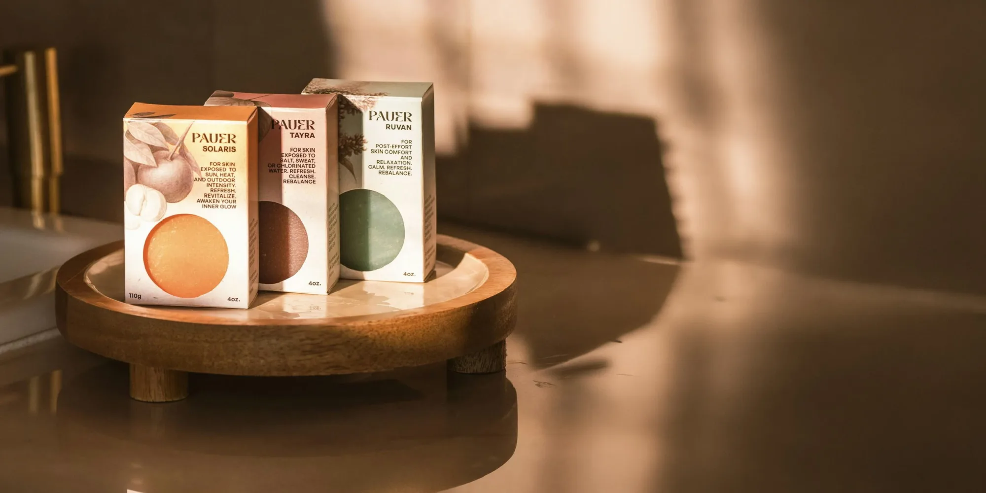 Las tres barras PAUER, SOLARIS, TAYRA y RUVAN, en sus cajas sobre una bandeja de madera con luz de ventana